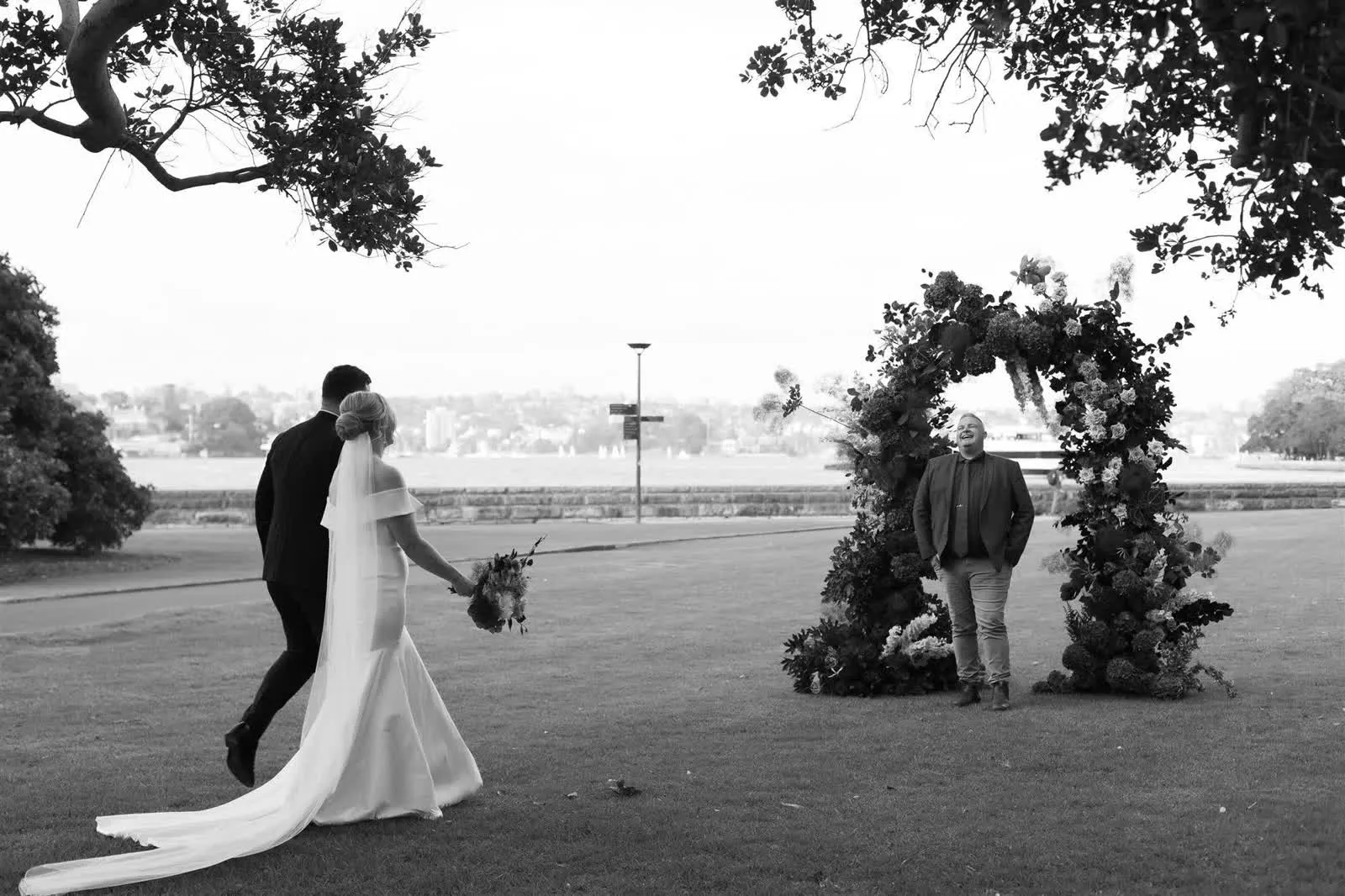 A bride and groom laughing with Josh Withers during their Sydney wedding ceremony